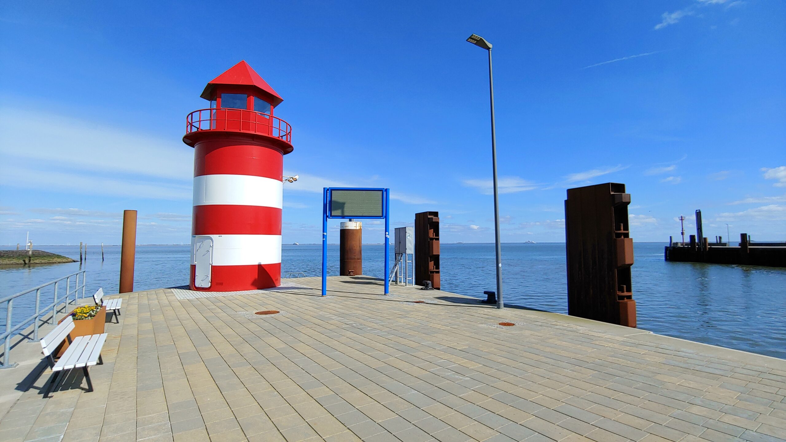 Fotomotive auf Föhr: Hafenleuchtturm auf Föhr in Wyk, strahlend vor einem malerischen Himmel mit vorbeiziehenden Wolken ist eines von vielen Sehenswuerdigkeiten auf Foehr